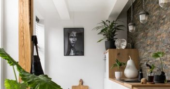 Du carrelage dans toutes les pièces : c’est possible ? cuisine dans les tons blanc et ois avec mur en pierre et plante