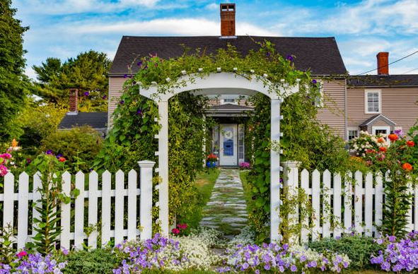 Entrée d'un jardin avec barrières blanches fleuries