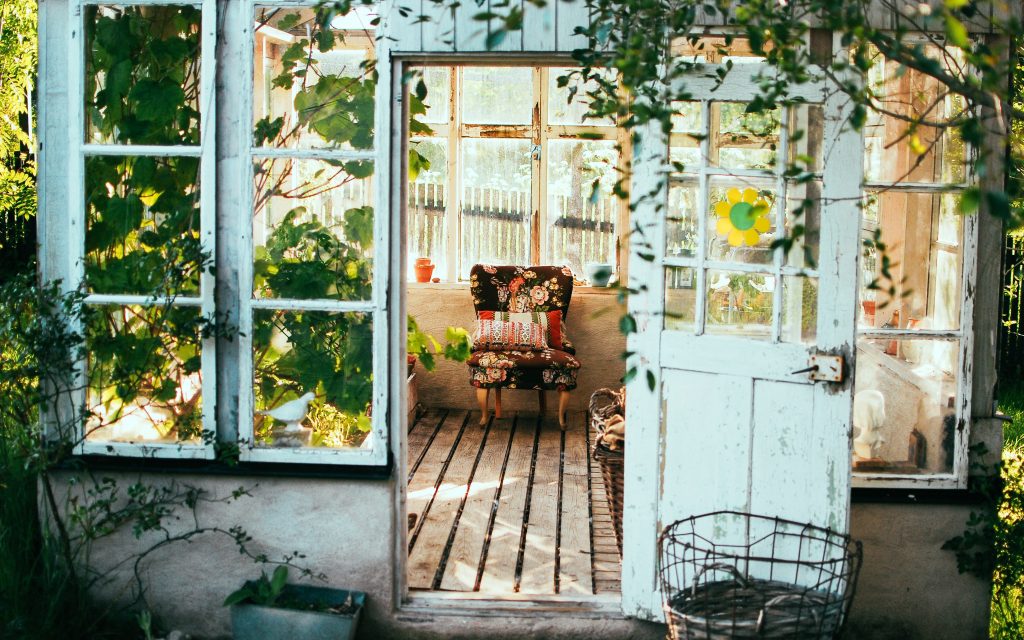 Abri de jardin et serre avec chaise et plantes